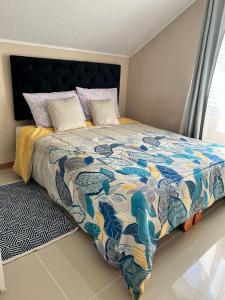 een slaapkamer met een bed met een kleurrijk dekbed bij Amplia Casa 8 dormitorios 4 baños Avenida Lircay in Talca