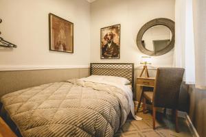 a bedroom with a bed and a desk and a mirror at pension Acronafplia ( building C ) in Nafplio