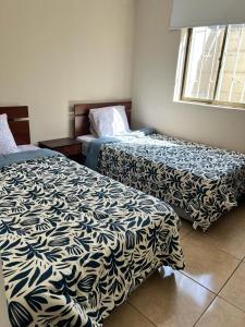 twee bedden naast elkaar in een kamer bij Amplia Casa 8 dormitorios 4 baños Avenida Lircay in Talca