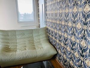 eine Couch neben einer Wand mit einem Fenster in der Unterkunft Design apartment in Bratislava