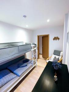 ein Schlafzimmer mit einem Etagenbett und einem Tisch in der Unterkunft Ferienwohnung am Rabenauer Grund in Freital