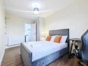 1 dormitorio con cama con almohadas de color naranja y escritorio en Rooms Near City Centre Private Bath Free Parking, en York