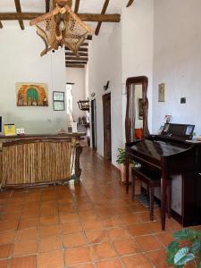 sala de estar con piano y espejo en Hostería Doña Vivi, en Barichara
