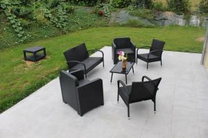 a group of chairs and tables on a patio at Maison en Normandie in Londinières