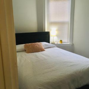 a bedroom with a white bed with a window at Modern Logan Square 1 bedroom Flat in Chicago