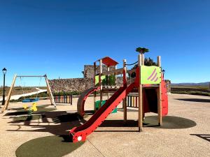 a playground with a slide and a slideintend at Casa Rural Muralla de Haza in Haza