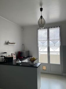 cocina con encimera negra y ventana en Élégant appartement - Accor Arena Bercy, en Ivry-sur-Seine