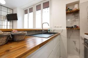 a kitchen with a sink and a wooden counter top at studio lumineux à BORDEAUX CHARTRONS / JARDIN PUBLIC in Bordeaux