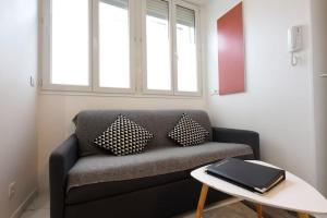 a living room with a couch and a table at studio lumineux à BORDEAUX CHARTRONS / JARDIN PUBLIC in Bordeaux