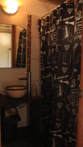 a bathroom with a shower curtain and a sink at La Quinta Hostel & Suites in Punta del Este