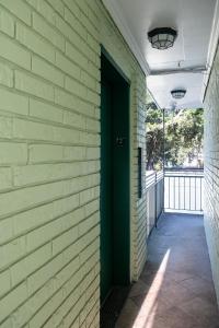 a hallway with a green door on a brick wall at French Quarter Suites Hotel in New Orleans