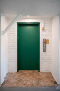 uma porta verde numa parede de tijolos brancos em French Quarter Suites Hotel em Nova Orleans