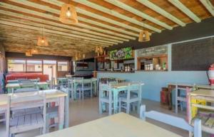 a restaurant with tables and chairs and a chalkboard at La Quinta Hostel & Suites in Punta del Este