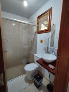 a bathroom with a shower and a toilet and a sink at Toca do Roka in Socorro