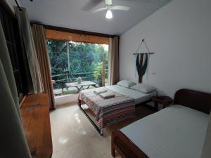 a bedroom with a bed and a couch and a window at Toca do Roka in Socorro