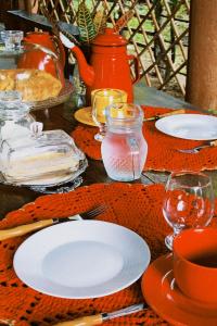 a table with plates of food and glasses on it at Sítio Primavera in Ipueiras