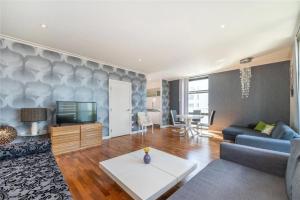 a living room with a couch and a tv at Penthouse Canary Wharf - Free WiFi in London