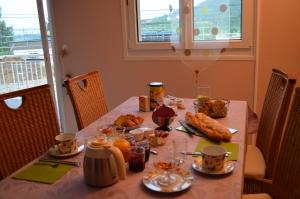 een tafel met eten en drinken erop bij Chambre d'Hôtes Plesnois 