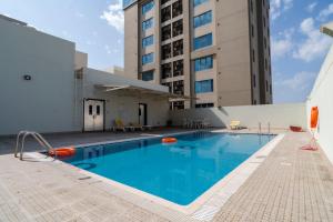 a swimming pool in the courtyard of a building at Amber Tower in Al Ghurayfah