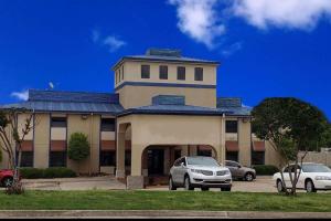 a building with cars parked in front of it at Baymont by Wyndham Ardmore I-35 in Ardmore