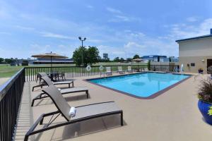 - une piscine avec des chaises longues à côté d'un bâtiment dans l'établissement Baymont by Wyndham Ardmore I-35, à Ardmore