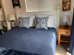a bedroom with a bed with blue and white pillows at Oceanfront Cabin 4 with Jacuzzi Pet Friendly in Smith River