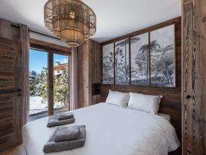 a bedroom with a white bed and a large window at Résidence Ksar A - 4 Pièces pour 6 Personnes 631 in Megève