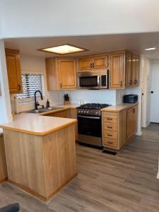 a kitchen with wooden cabinets and a stove top oven at Oceanview Cabin 22 W Jacuzzi & Wonderful View in Smith River