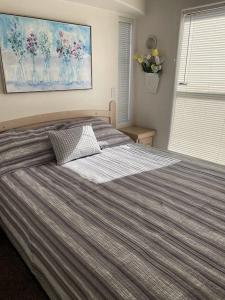 1 dormitorio con 1 cama grande con manta a rayas en Oceanview Cabin 28 W Jacuzzi & Terrific Views, en Smith River