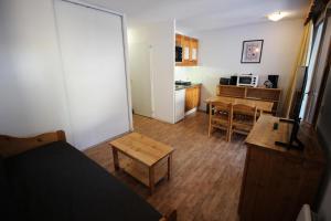 a room with a bed and a table and a kitchen at Chalets De La Vanoise - 2 Pièces pour 4 Personnes 171 in Villarodin-Bourget