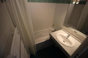 ein Badezimmer mit einem Waschbecken und einer Badewanne in der Unterkunft Chalets De La Vanoise - 2 Pièces pour 4 Personnes 171 in Villarodin-Bourget