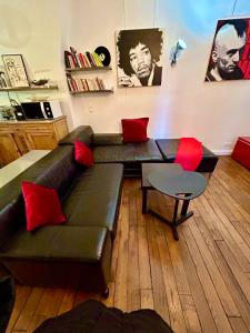 sala de estar con sofá negro y almohadas rojas en Paris Welcome en París