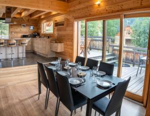 a dining room with a table and chairs and a kitchen at Résidence Pramouton - Chalets pour 9 Personnes 591 in Le Mélézet