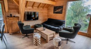 a living room with a couch and chairs and a tv at Résidence Pramouton - Chalets pour 9 Personnes 591 in Le Mélézet
