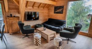 a living room with a couch and chairs and a tv at Résidence Pramouton - Sublime chalet aux grands espaces de convivialité MAE-3591 in Le Mélézet