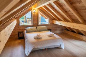 a bedroom with a bed in a wooden attic at Résidence Pramouton - Chalets pour 9 Personnes 591 in Le Mélézet