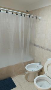 a bathroom with a toilet and a shower curtain at Nehuen APartB in Neuquén
