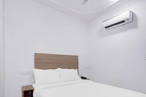 a bedroom with a white bed and a air conditioner at Hotel Grand Capitol-2 in Jaipur