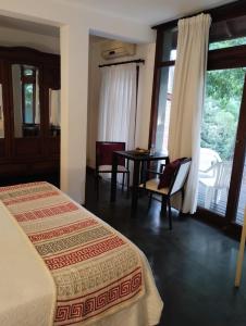 マール・デ・ラス・パンパスにあるPosada La Casonaのベッドルーム1室(ベッド1台、テーブル、椅子付)