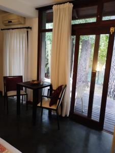 瑪爾德拉斯潘帕斯的住宿－Posada La Casona，一间带桌椅的用餐室和滑动玻璃门
