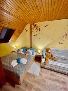 un osito de peluche sentado en dos camas en una habitación en Marta Guest House en Gyenesdiás