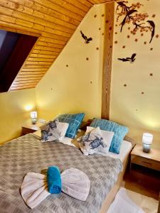 duas camas num quarto com pássaros na parede em Marta Guest House em Gyenesdiás