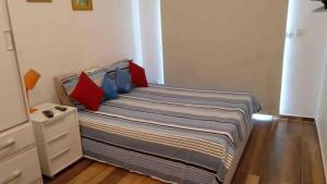 a bedroom with a bed with red and blue pillows at Flat Studio Charmoso New Studio Granja Viana Cotia Sao Camillo 642 in Carapicuíba +6 photos