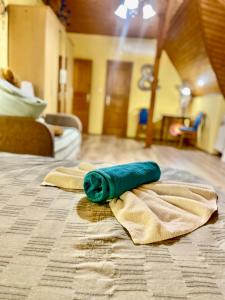 uma toalha verde enrolada em cima de uma cama em Marta Guest House em Gyenesdiás