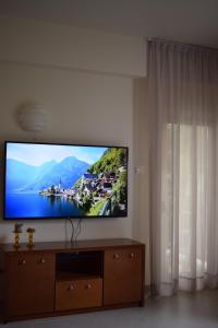 T&L Apartments Agiaos Tychonas في ليماسول: تلفزيون بشاشة مسطحة جالس على جدار في غرفة المعيشة