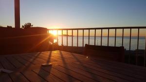 サン・フロランにあるAppartement 2 terrasses face mer de 100m2の木製デッキでの海上の夕日
