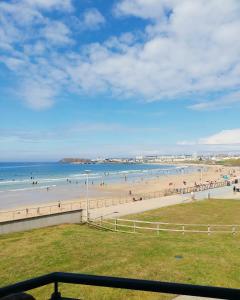 a view of a beach with people in the water at Luxurious Beach Front Apartment in Portrush in Portrush