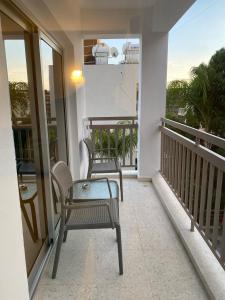 a balcony with two chairs and a table at T&L Apartments Agiaos Tychonas in Limassol