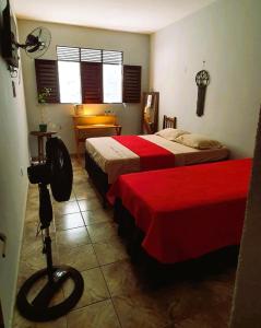 ein Hotelzimmer mit 2 Betten mit roter Bettwäsche in der Unterkunft Espaço Jardim Secreto Hostel in João Pessoa