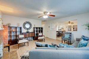 uma sala de estar com um sofá azul e uma cozinha em Breezy Fresno Home - Near Airport and Downtown em Fresno